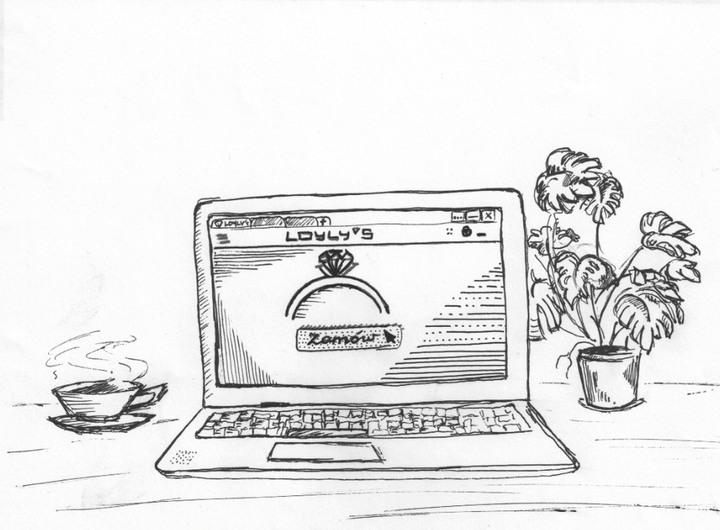Strona internetowa LOYLY'S otwarta na laptopie stojącym obok kawy i kwiatka
